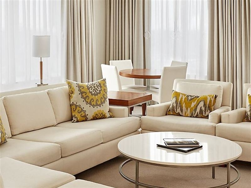 A living room with white couches and a round coffee table